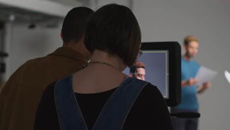 Actors-With-Scripts-In-Rehearsal-Shooting-Movie-Or-Video-In-Studio-With-Film-Crew-And-Female-Director-Watching-Monitor-In-Background-3